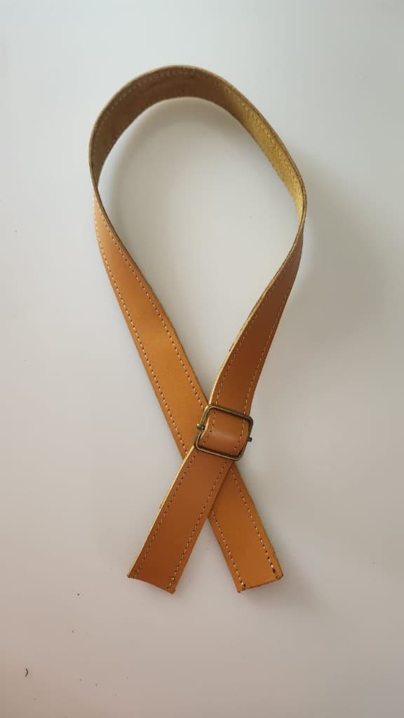 Tan leather crossbody strap with brass buckle by Plaasjaap