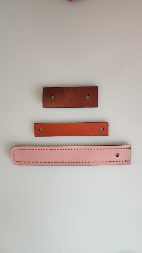 Leather bag fastening straps in brown, tan, and pink by Plaasjaap