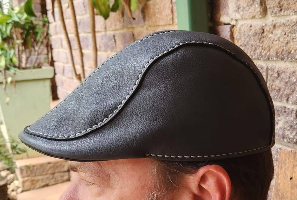 Handmade dark leather flat cap with contrast stitching by Plaasjaap